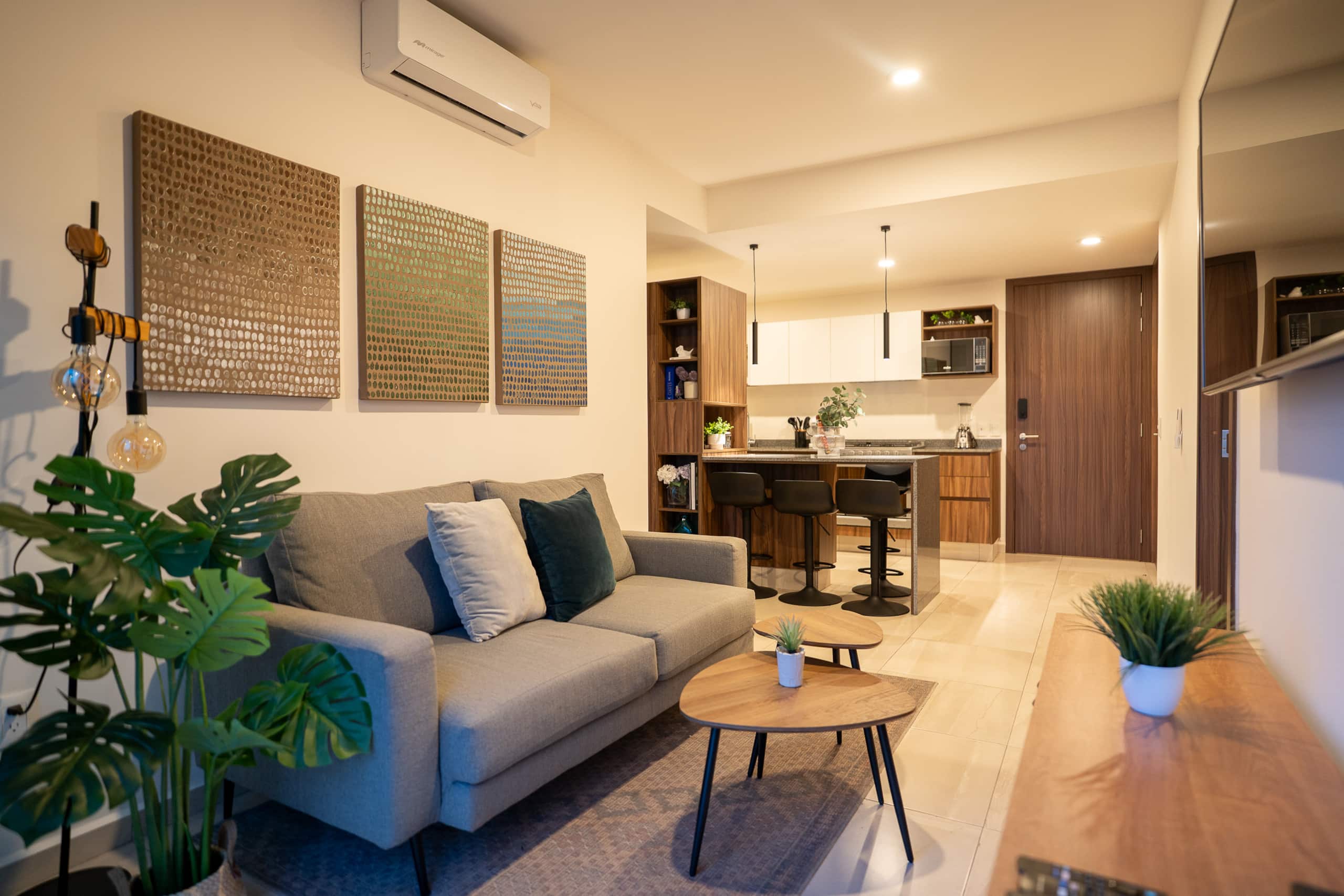Sala con sofá gris y barra de cocina
