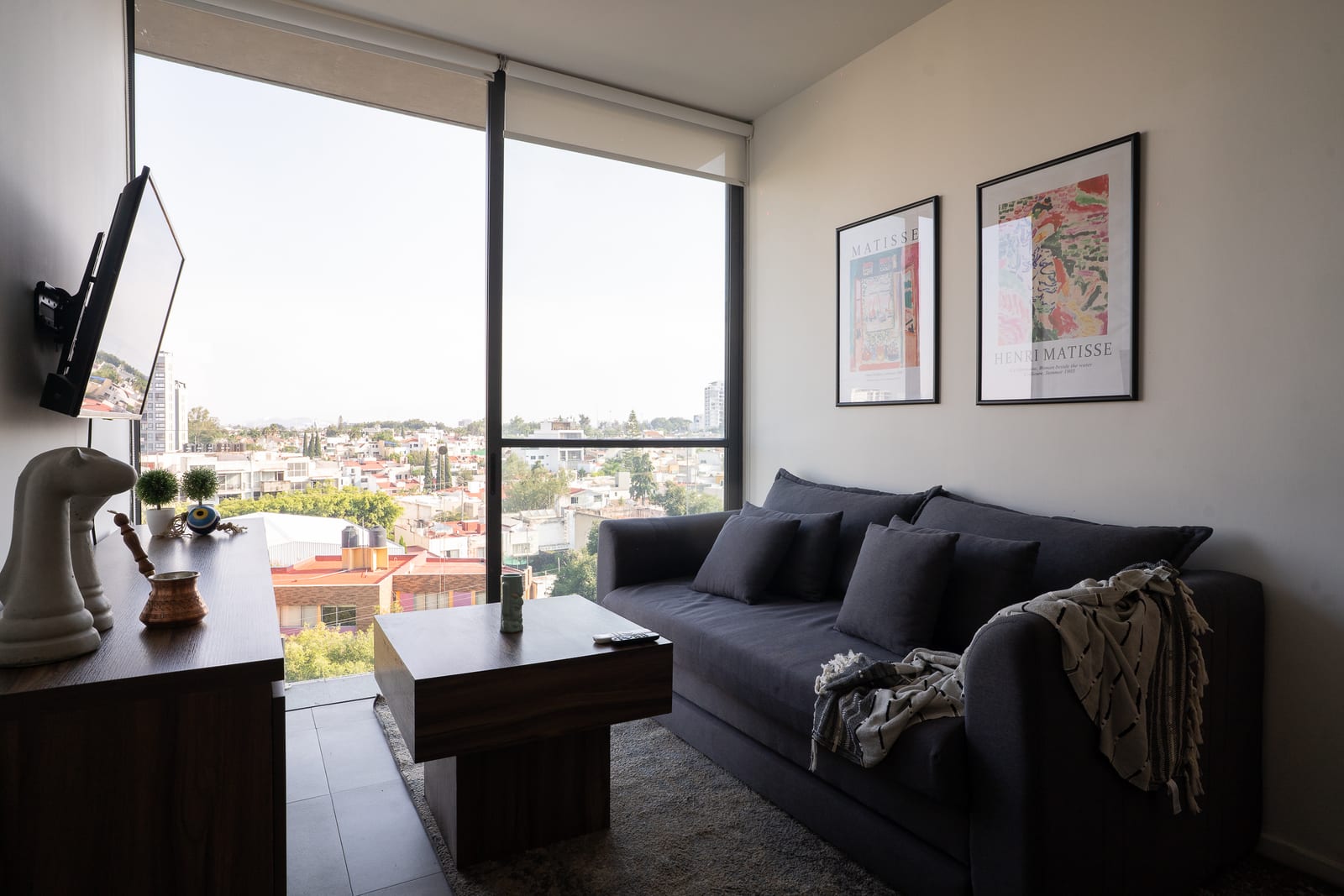 Sala con sofá gris y gran ventanal